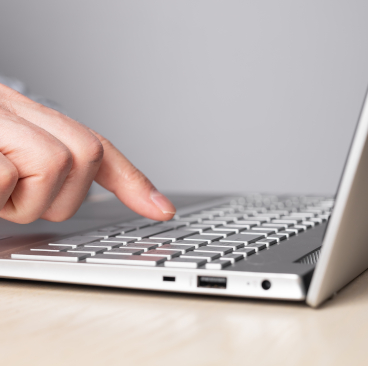 Eine Person bedient den Laptop.